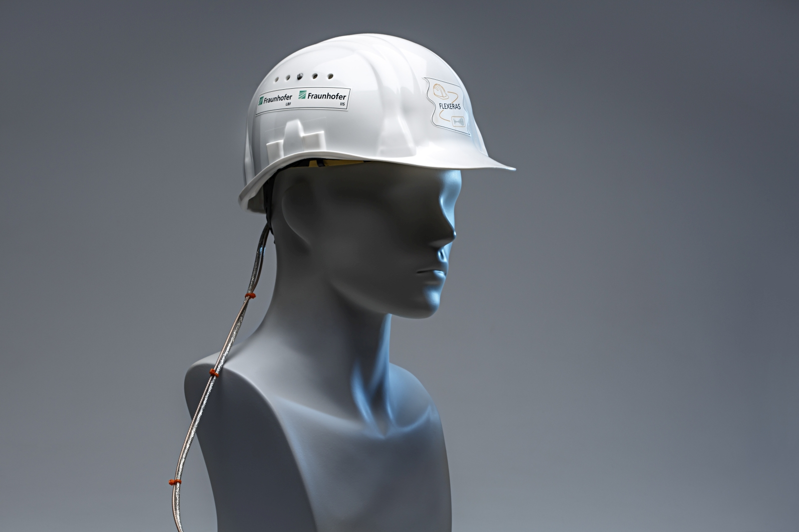 Der Piezo-Elektret-Wandler ist unauffÃ¤llig im inneren Befestigungsriemen des Helms eingearbeitet. Das Foto zeigt einen Demonstrator der Technik. (Bild: Â©Ursula Raapke/Fraunhofer-Institut LBF)
